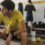 Manger une banane avant le sport, coureur assis avec banane